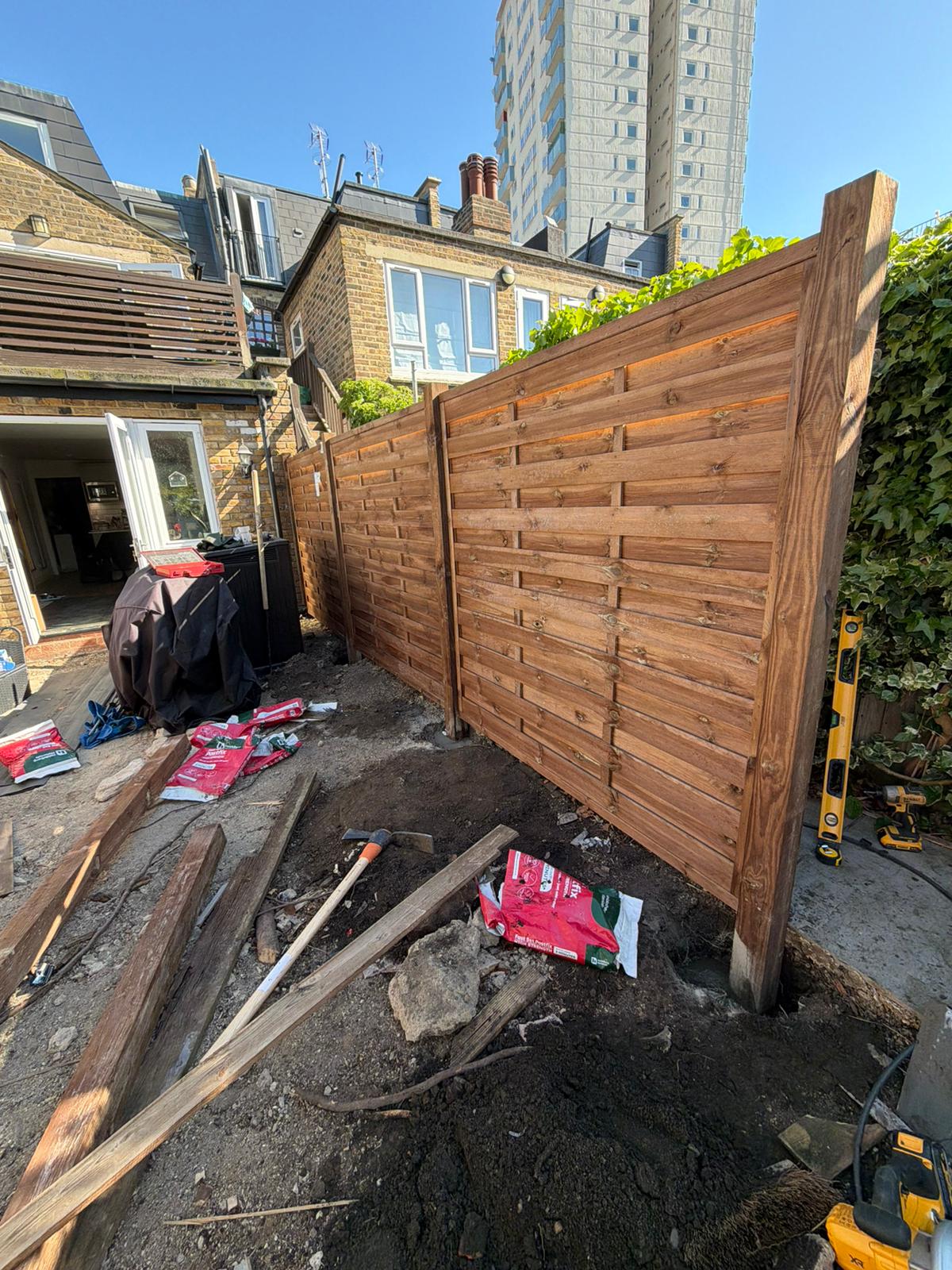 New horizontal timber fence panels being installed in Battersea garden