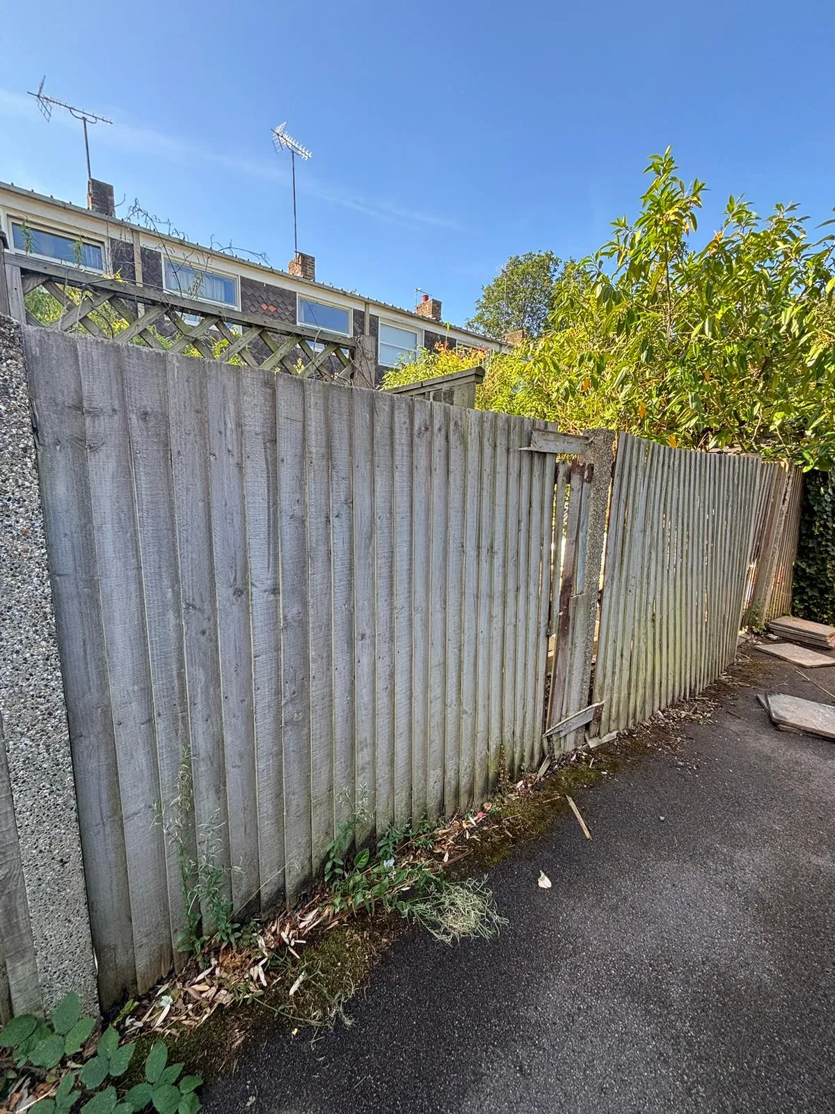 Leaning closeboard fence with cracked concrete post before repair in Blackheath SE3