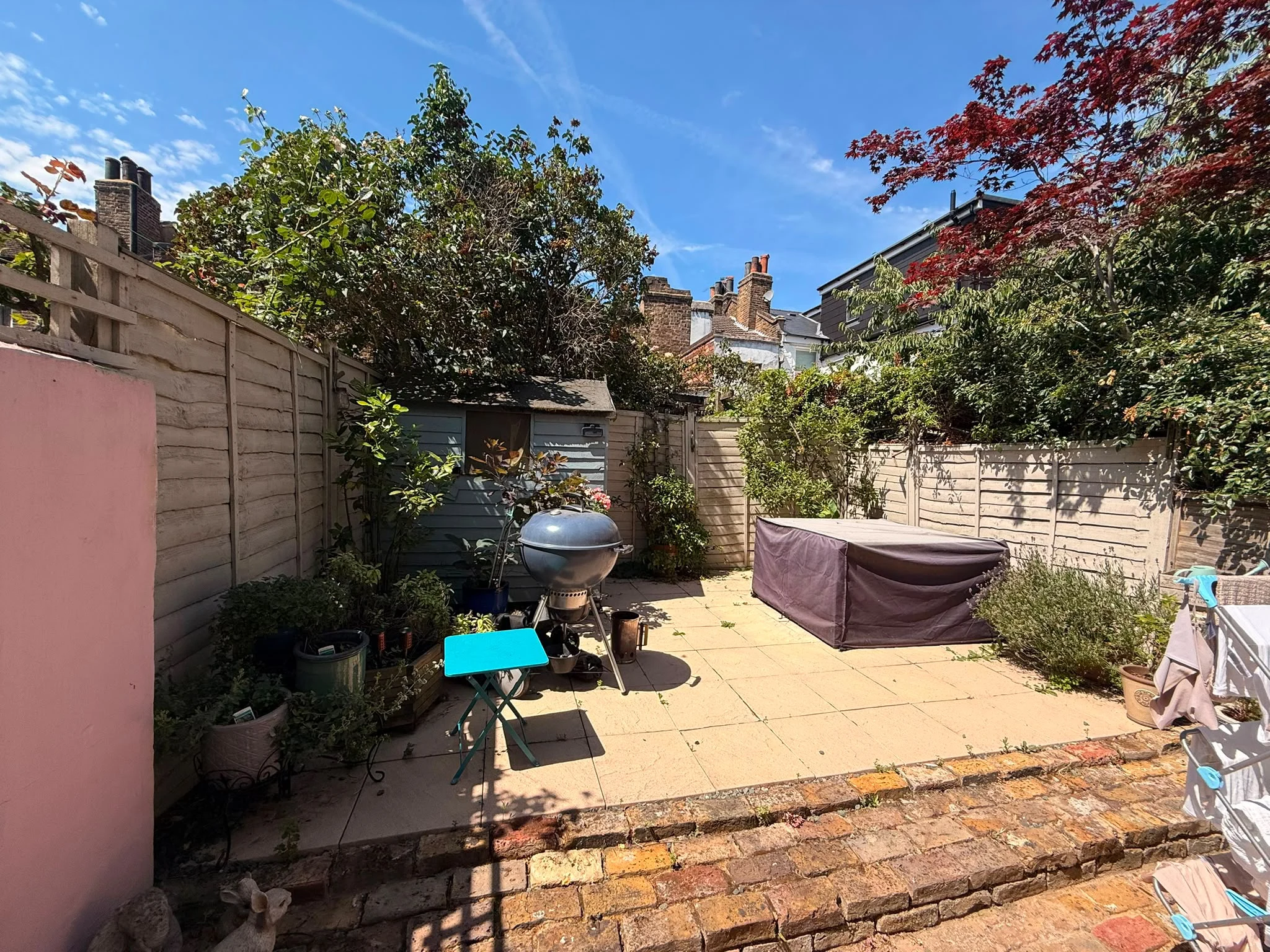 Original Greenwich garden before landscaping work, with old timber fence panels, plain patio slabs and garden shed prior to the new porcelain patio, pergola and fencing