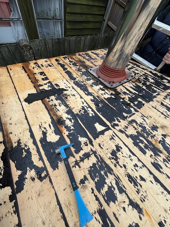 Old flashing removed around shed roof flue pipe during refelt
