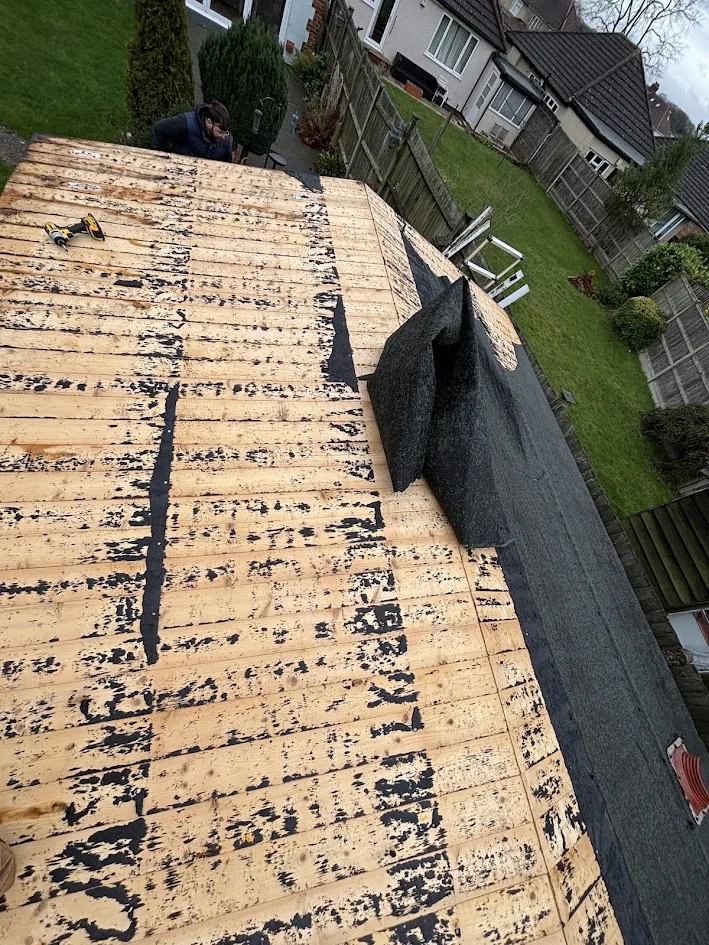 Shed roof before refelting, showing torn and perished old felt